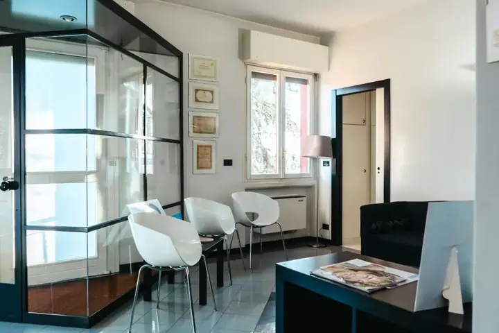La sala d'attesa dello studio, luminosa, con le poltroncine bianche